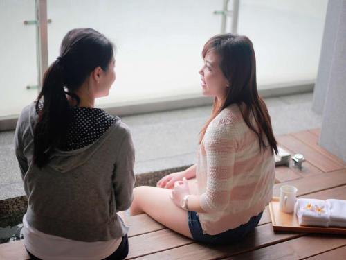 two girls sitting on the floor looking out the window at ISPAVITA B&B Resort in Jiaoxi