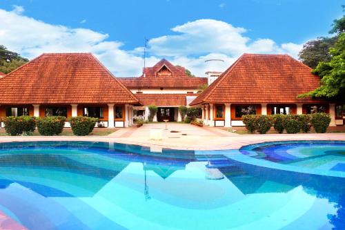 a large swimming pool in front of two buildings at Bolgatty Palace & Island Resort in Cochin