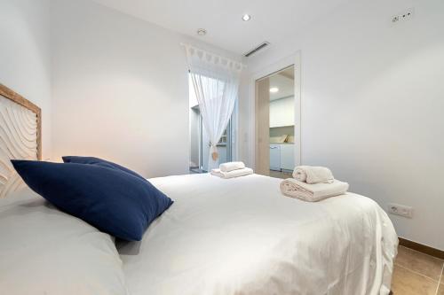 a bedroom with a large white bed with towels on it at Mabicarent Playa 1 in Calafell
