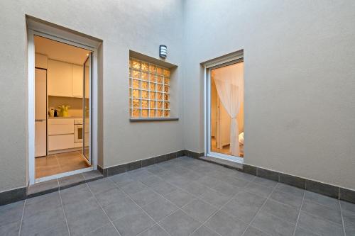 an empty room with two windows and a kitchen at Mabicarent Playa 1 in Calafell