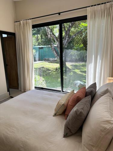 a bedroom with a bed with a large window at Casa Makuira 2 in El Valle de Antón