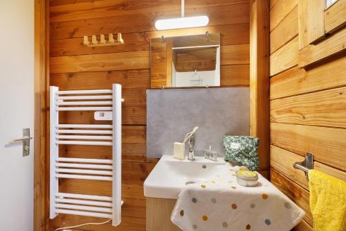 a bathroom with a sink and wooden walls at Chalet prestige 19 piscine partagée in Saint-Gervais