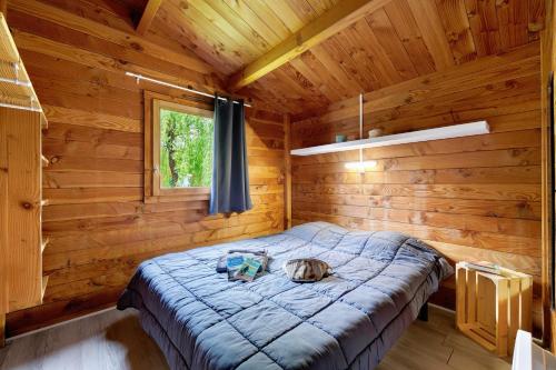 a cat laying on a bed in a log cabin at Chalet prestige 19 piscine partagée in Saint-Gervais