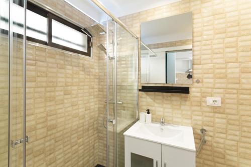 a bathroom with a sink and a glass shower at Casa Neale in Puerto Rico de Gran Canaria