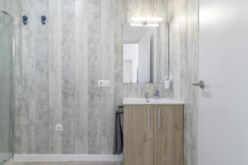 a bathroom with a sink and a mirror and a shower at Casa Sofia in Conil de la Frontera