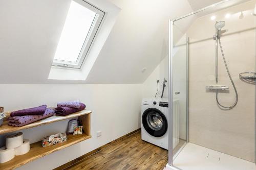 a bathroom with a shower and a washing machine at Ferienwohnung zum Heubalken in Schmallenberg
