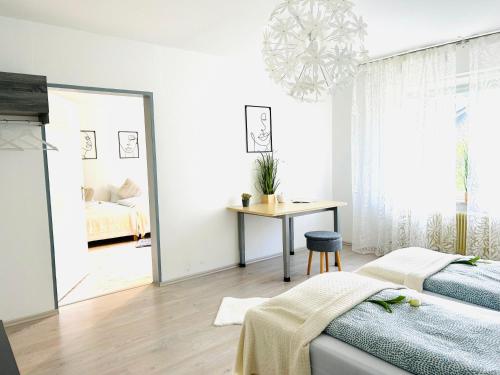 un dormitorio con una cama, una mesa y un espejo en Apartment Alb Glück 1, en Hechingen