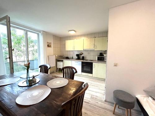 una cocina y comedor con mesa y sillas de madera en Apartment Alb Glück 1, en Hechingen