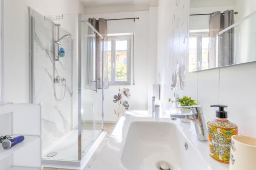 a white bathroom with a shower and a sink at Villa Tosca dell'Angelo con piscina in Comiso