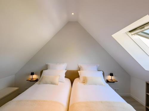 two beds in a attic bedroom with white ceilings at L'Ascalon in Saint-Sauveur-le-Vicomte
