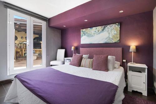 a purple bedroom with a large bed and a window at La Suerte viviendas in Agaete