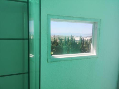 a window in a bathroom with a green wall at Roca Caravan in Estepona