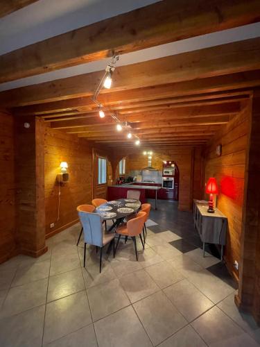 a kitchen and dining room with a table and chairs at Le Chalet de Noblat in Saint-Léonard-de-Noblat