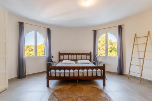 a bedroom with a bed and two windows at Fantastisic villa - Great location in Moraira