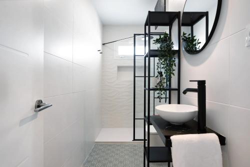 a white bathroom with a sink and a mirror at Ula Home in Barbate