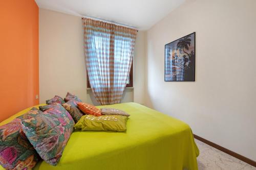a bedroom with a bed with a yellow blanket at vista lago apartment 2 in Soiano del Lago