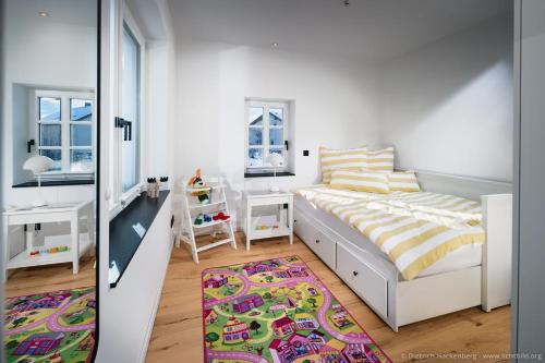 a white bedroom with a bed and a rug at Fachwerkhaus Eiben in Kirchhundem