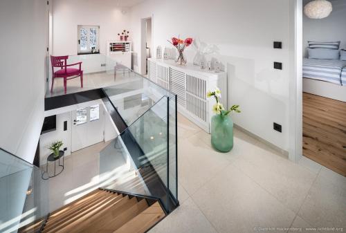 a glass staircase in a living room with a vase of flowers at Fachwerkhaus Eiben in Kirchhundem