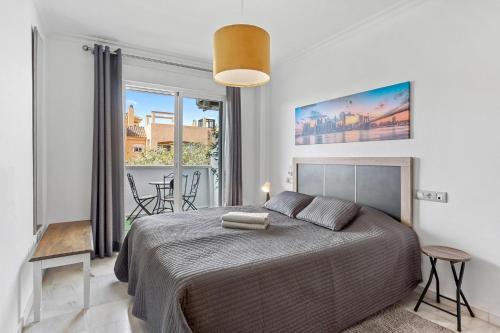 a bedroom with a large bed and a balcony at Malvarrosa A103 in Fuengirola