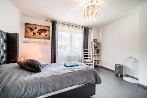 a bedroom with a bed and a large window at Villa L'Oranaise in Cluses