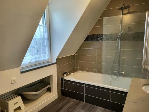 a bathroom with a shower and a bath tub at L'hermitage, Villa Front De Mer in Pirou