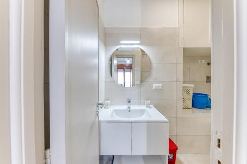 a white bathroom with a sink and a mirror at Franza 1 in Torre San Giovanni Ugento
