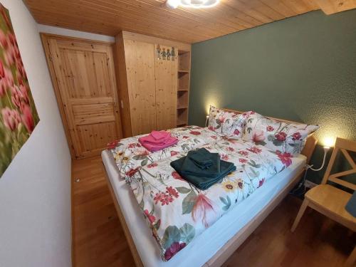 a bedroom with a bed with a floral bedspread at Kopf Frei auf 1000 Meter Wohnung 1 in Feldberg