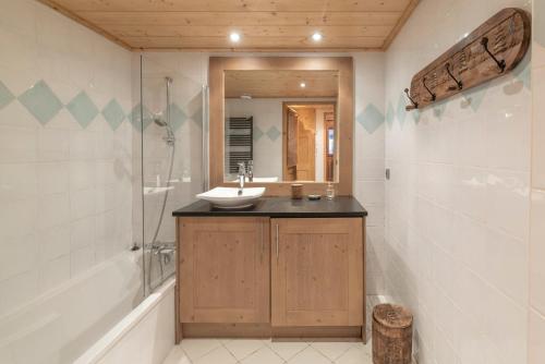 a bathroom with a sink and a shower and a mirror at App 6 pers cozy centre Samoëns in Samoëns