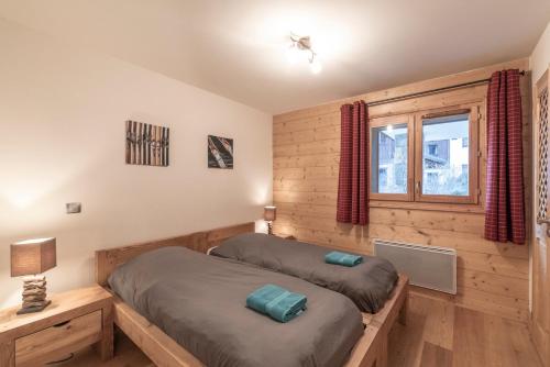 a bedroom with two beds and a window at App 6 pers cozy centre Samoëns in Samoëns