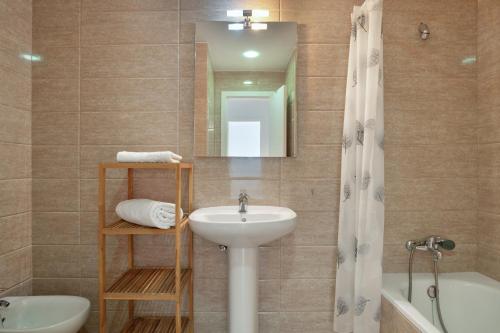 a bathroom with a sink and a toilet and a mirror at Casa Boliches32 in Arcos de la Frontera