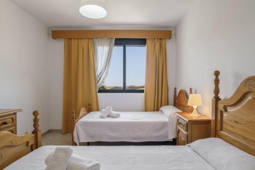 a bedroom with two beds and a window at Casa Boliches32 in Arcos de la Frontera