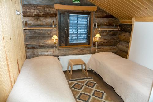 a bedroom with two beds and a window and a stool at Aamukka A&B in Levi