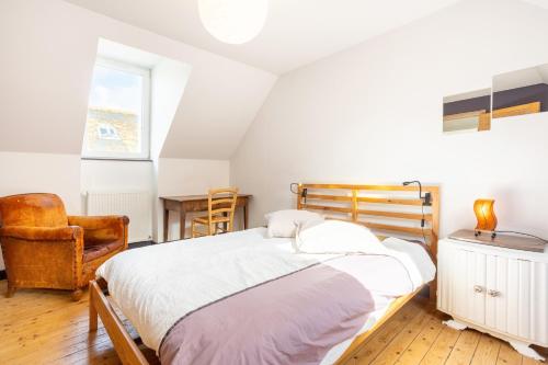 a bedroom with a bed and a chair at Maison de pêcheur au Rosmeur in Douarnenez