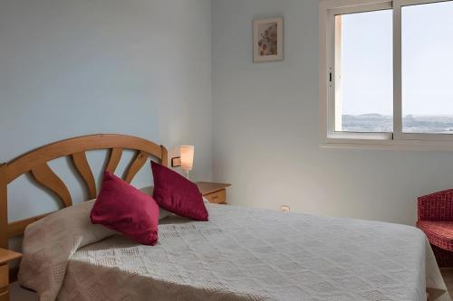 a bedroom with a bed with two red pillows on it at Villa Granvista by Easy Brava in Calonge