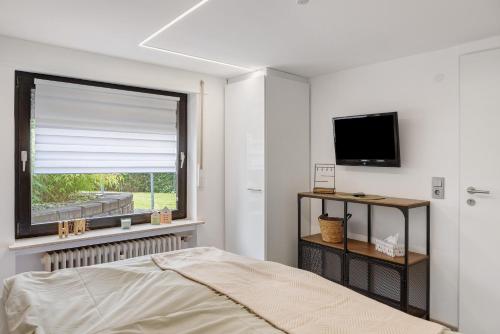 a bedroom with a window and a bed and a television at Fewo Goldbach in Eschwege