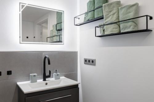 a bathroom with a sink and a mirror and towels at Fewo Goldbach in Eschwege