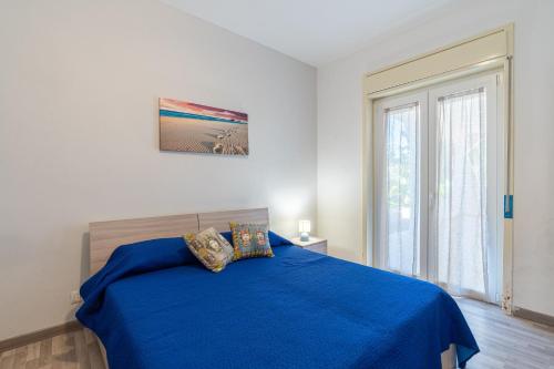 a bedroom with a blue bed and a window at Villa Fontane Bianche-Private Pool in Fontane Bianche