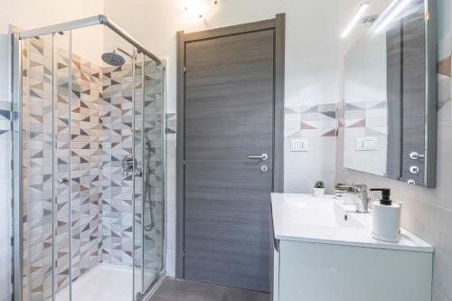 a bathroom with a shower and a sink and a mirror at Villa Fontane Bianche-Private Pool in Fontane Bianche