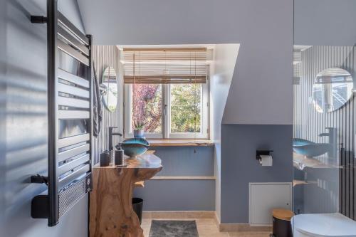 a bathroom with a sink and a window at La clé des Champs in Couffy