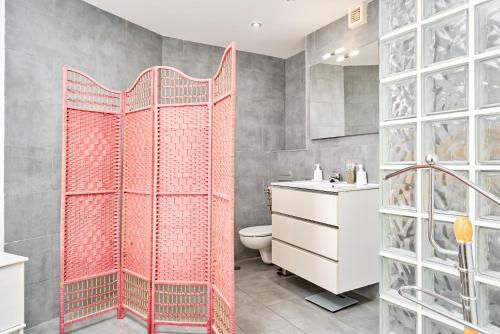 a bathroom with a toilet and a red shower curtain at Atico Carabela By Ist in Torrox