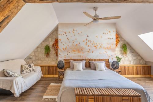 a bedroom with a large bed and a couch at La clé des Champs in Couffy