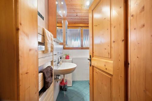 a bathroom with a sink and a wooden door at Ebnichers Paradies in Cardano