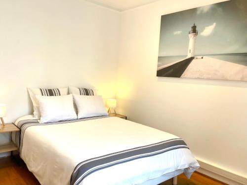 a bedroom with a bed with a picture of a lighthouse at Maison Villa Foch in Meaux