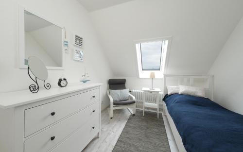 a bedroom with a bed and a dresser and a mirror at Ferienwohnung Barsch in Rade