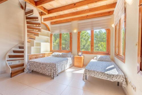 a bedroom with two beds and a staircase at Villa Costa De Blanes in Calvià