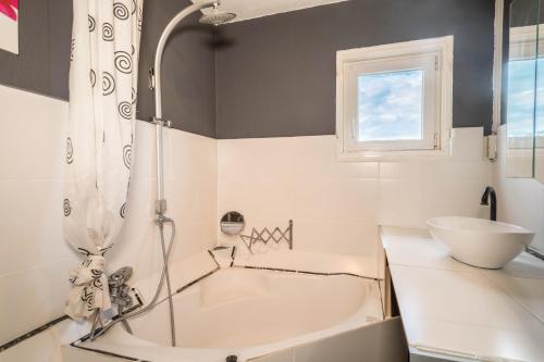a white bathroom with a tub and a sink at Ferienwohnung Idylle in Wasserburg