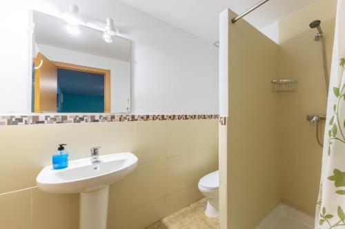 a bathroom with a sink and a toilet and a mirror at El Calderillo in Burgohondo