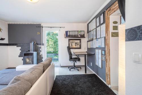 a bedroom with a couch and a desk in a room at Ferienwohnung Idylle in Wasserburg