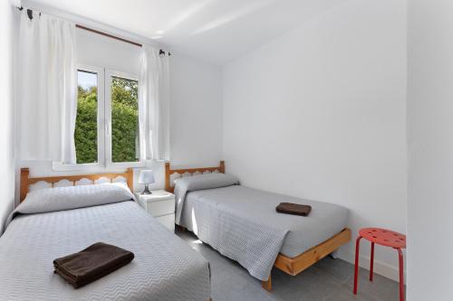 a bedroom with two beds and a window at La Gardenia 41 in Es Castell