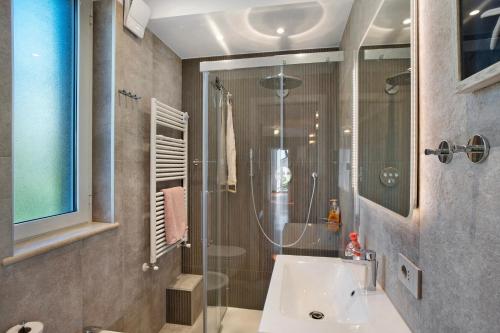 a bathroom with a shower and a white sink at Villa Vallegrande in Ospedaletti